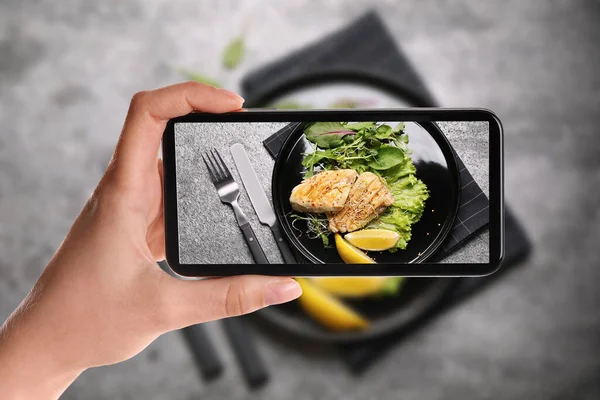 博客在餐桌边拍摄美味烤鱼的照片 食品摄影 — 图库照片