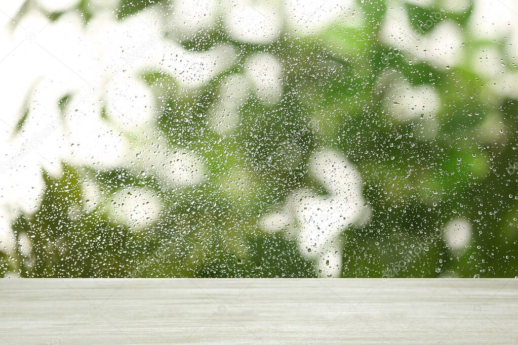 White wooden table near window on rainy day