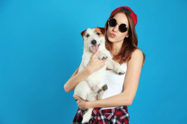 Açık mavi arka planda sevimli Jack Russell Terrier 'ı olan genç bir kadın. Sevimli hayvan