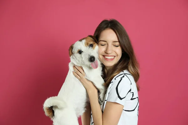 stock image Young woman with her cute Jack Russell Terrier on pink background. Lovely pet