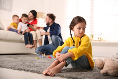 Ebeveynler diğer çocuklarla evde vakit geçirirken mutsuz küçük kız kıskançlık hissediyor.