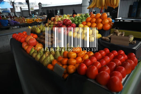 Barcode and tasty fresh fruits on counter at wholesale market