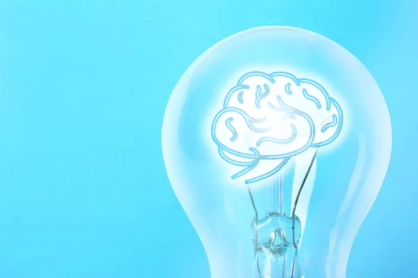 ライトブルーの背景に人間の脳とランプ電球 テキストのためのスペース アイデア生成 — ストック写真