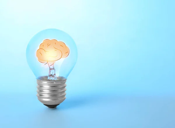 青色の背景に人間の脳とランプ電球 テキストのためのスペース アイデア生成 — ストック写真