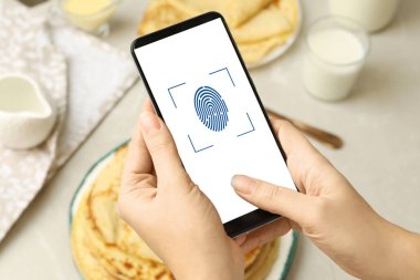 İçerideki akıllı telefondan parmak izi taraması yapan kadın, yakın plan. Dijital kimlik