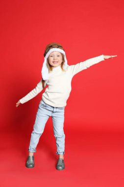 Kırmızı arka planda küçük şirin bir kızın portresi.