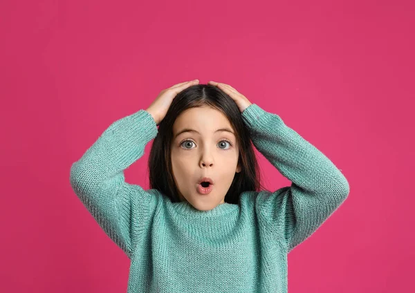Pembe arka planda küçük şirin bir kızın portresi.