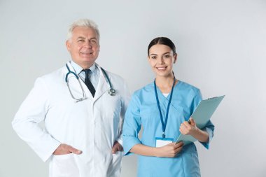 Kıdemli doktor ve genç hemşire arka planda