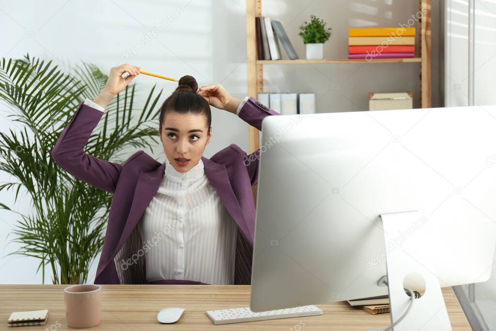 Lazy employee playing with pencil at table in office