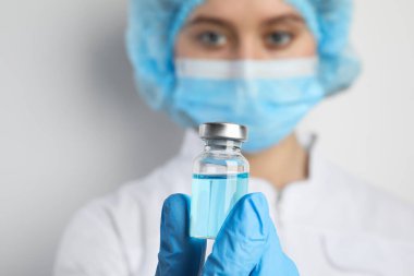 Doktorun elinde ilaç şişesi var, yakın plan. Aşılama ve aşılama