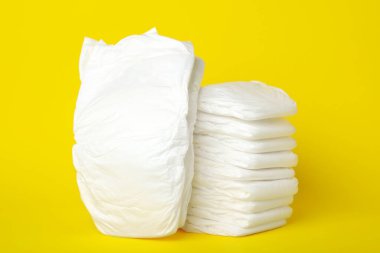 Sarı arka planda bebek bezi yığını