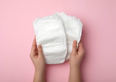 Pembe arka planda bebek bezi olan kadın, yakın plan.