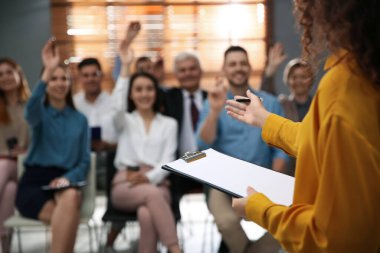Konferans salonundaki seminerde iş eğitmeni soruları cevaplıyor.