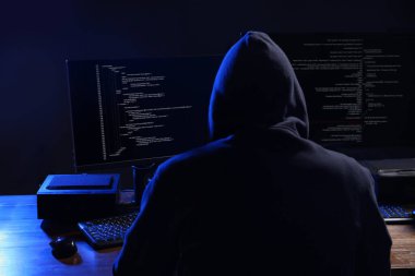Karanlık odada bilgisayarları olan bir bilgisayar korsanı. Siber Suçlar