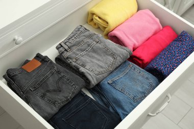 Açık çekmeceye katlanmış giysiler. Giysi deposu