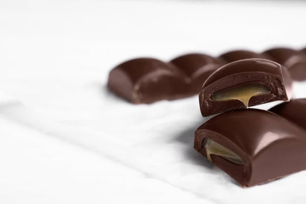 Trozos Chocolate Con Relleno Caramelo Mesa Blanca Primer Plano Espacio — Foto de Stock