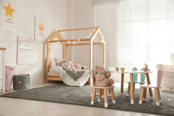 小さなテーブルと子供の寝室のインテリアでウサギの耳を持つ椅子 — ストック写真