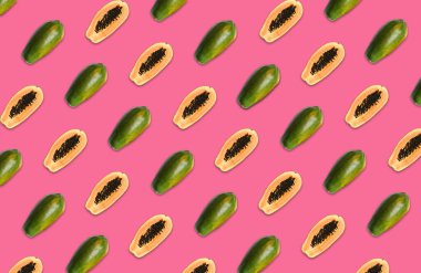 Pembe arka planda bütün ve yarı yarıya papaya meyvesi deseni