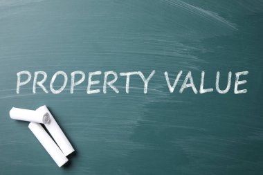 Yeşil karatahta beyaz tebeşir ve tabir Property VALUE parçaları, düz yatıyordu