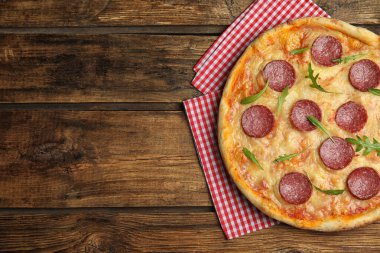 Ahşap masada nefis pepperonili pizza, üst manzara. Metin için boşluk