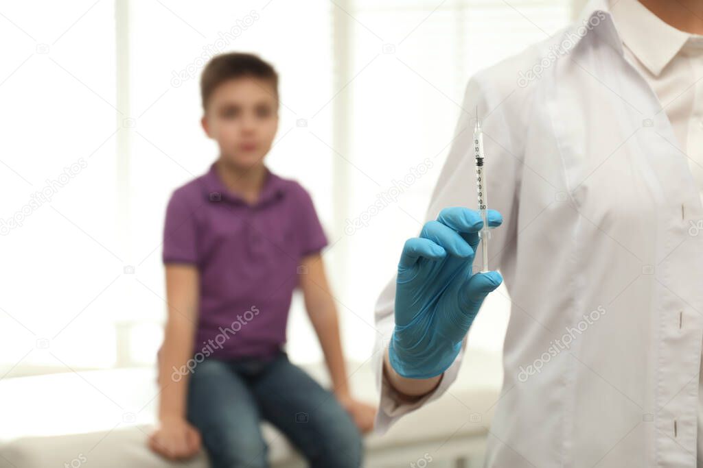 Doctor with syringe in clinic, closeup. Vaccination day