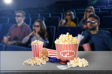 Patlamış mısır, 3D gözlükler, masa biletleri ve sinema salonundaki gençler.