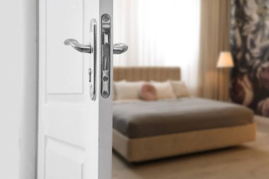 Modern otel odasına açılan beyaz kapı, yakın plan.