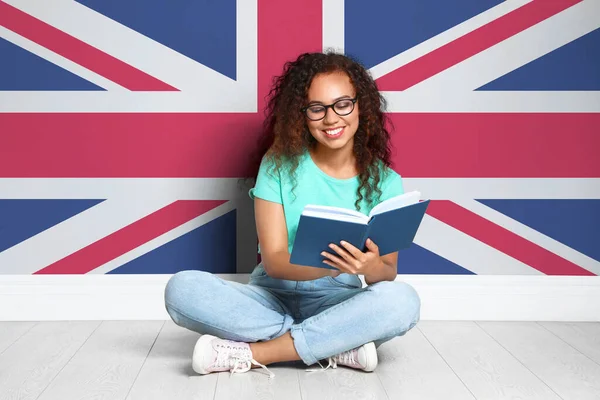 Vackra Unga Afroamerikanska Flicka Läsa Bok Och Flagga Storbritannien Väggen — Stockfoto