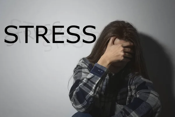 Beyaz Duvarın Stress Sözcüğünün Yanında Depresif Genç Bir Kadın — Stok fotoğraf