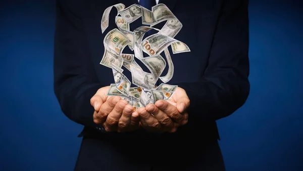 濃い青の背景に金を持つビジネスマン クローズアップ 通貨交換 — ストック写真