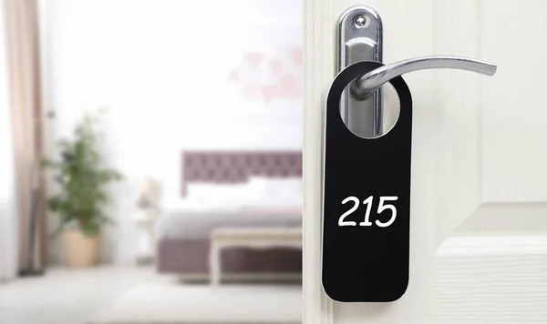 Open door with sign 215 on handle in hotel, closeup. Space for text