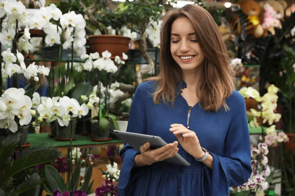 Young business owner with tablet in flower shop