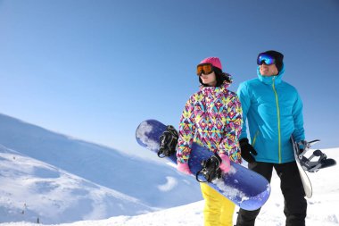 Dağlarda snowboard yapan mutlu bir çift. Kış tatili