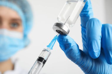 Şırıngayı ilaçla dolduran doktor, yakın çekim. Aşılama ve aşılama