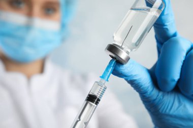 Şırıngayı ilaçla dolduran doktor, yakın çekim. Aşılama ve aşılama