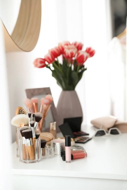 İçinde makyaj malzemeleri, aksesuarlar ve laleler olan bir makyaj masası. İç öge