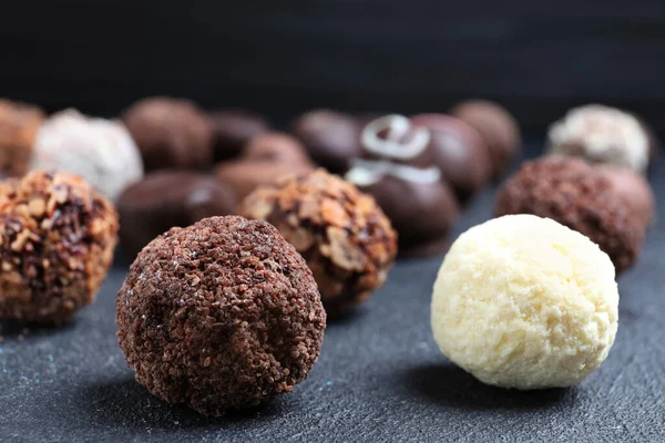 Verschiedene Leckere Schokoladenbonbons Auf Schwarzem Tisch Nahaufnahme — Stockfoto