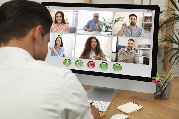 Man having video chat with colleagues at table in office, closeup. Team work