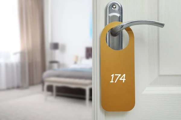 Open door with sign 174 on handle in hotel, space for text