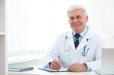 İş yerinde beyaz önlüklü kıdemli doktorun portresi.