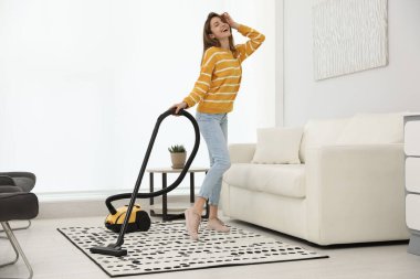 Evini süpürürken eğlenen genç kadın.