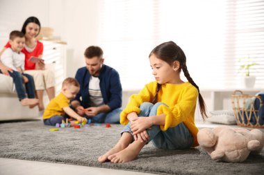 Ebeveynler diğer çocuklarla evde vakit geçirirken mutsuz küçük kız kıskançlık hissediyor.