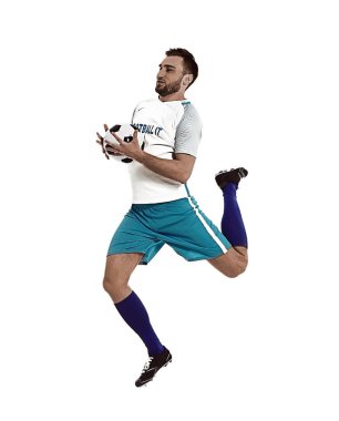 Genç adam beyaz arka planda futbol oynuyor.