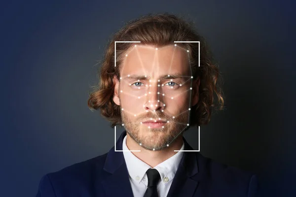 Facial recognition system. Businessman with scanner frame and digital biometric grid on dark background