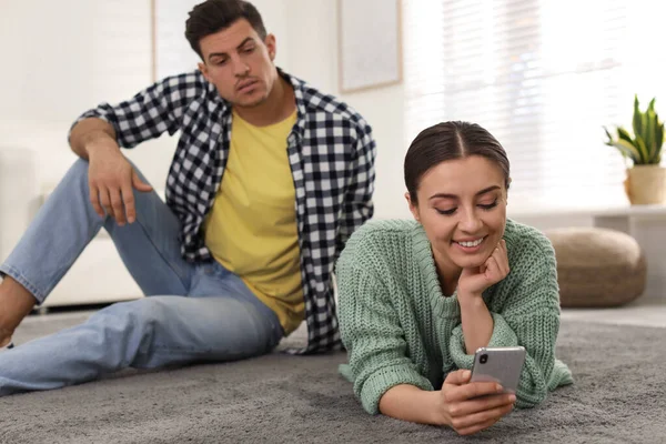 Distrustful Man Peering Girlfriend Smartphone Home Jealousy Relationship — Stock Photo, Image