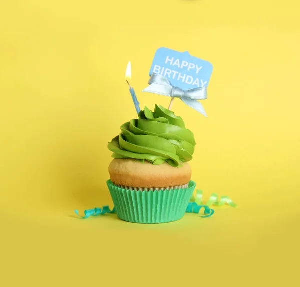 黄色の背景に美しい誕生日カップケーキとストリーマー — ストック写真