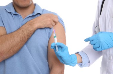 Doktor beyaz arka planda hastaya iğne yapıyor, yakın plan. Aşılama kavramı