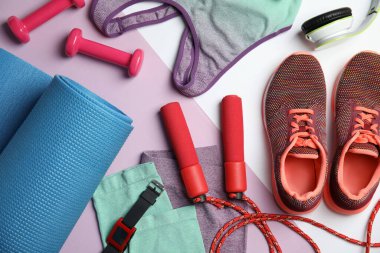 Renk arkaplanındaki fitness ekipmanlarıyla düz konum