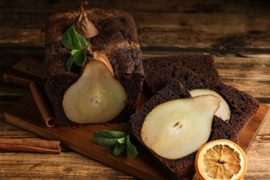 Naneli armut ekmeği, tarçın ve ahşap masada kurutulmuş portakal dilimleri. Ev yapımı kek.