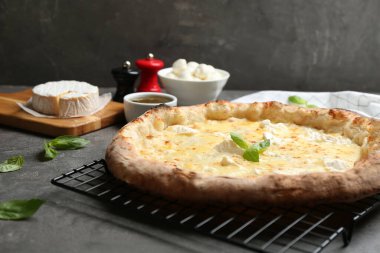 Gri masada leziz sıcak peynirli pizza.